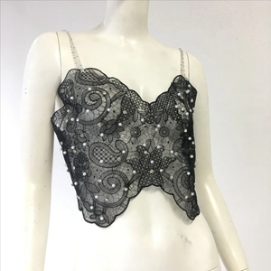 Detail of black lace crop top with white pearls, crystals and beaded straps