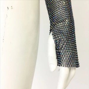 Détail des manches en résille noire ornées de strass irisés pour les festivals de musique