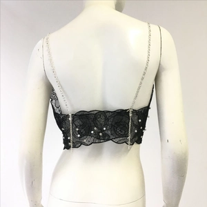 Detail of black lace top with pearl beads, rhinestone decor and chain strap back