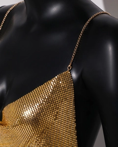 Close-up of golden sequin chain link vest showing detailed metallic scale texture