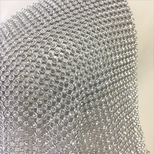 Détail du tissu en maille strass scintillante avec monture en métal argenté pour haut