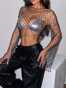 Detail of sheer mesh long sleeve top featuring sparkling rhinestones and floral accents