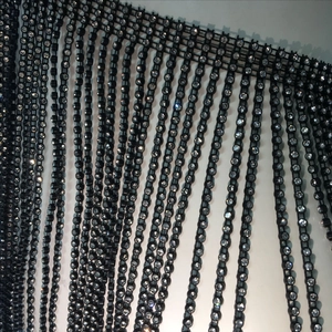 Détail du haut dos nu en résille avec strass et franges pour festivals de musique