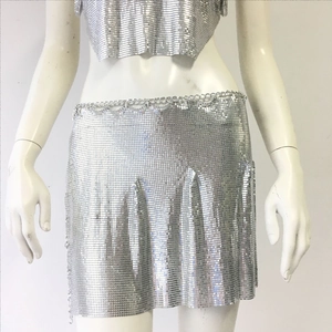 Dettaglio del crop top in mesh metallica argento e minigonna a pieghe per i festival