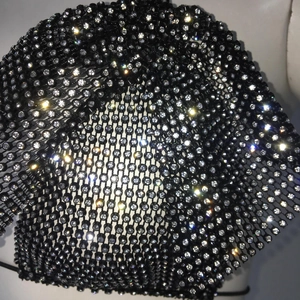 Macro view of black fishnet fabric with sparkling silver rhinestones on the top