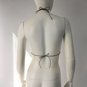Detail of black halter bikini top with back ties and bow knots on a female mannequin