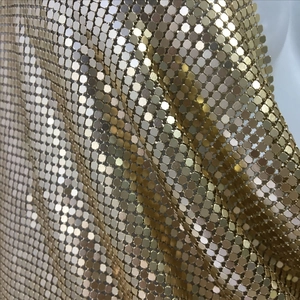 Detail of gold metallic sequin mesh fabric with reflective hexagonal metal plates