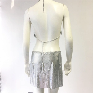 Dettaglio del completo due pezzi in paillettes argento con top scoperto e minigonna