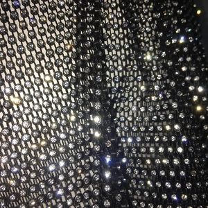 Detailed close-up of high-density rhinestones on black mesh fabric for festival wear