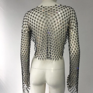 Detail of black mesh long-sleeve top with colorful rhinestones and floral patterns