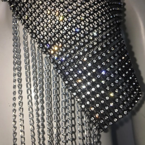Macro detail of sexy rhinestone fishnet top featuring silver tassel chain fringe accents