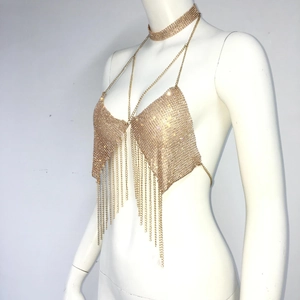 Detailed view of golden rhinestone mesh halter top with metallic tassels and choker