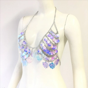 Macro detail of layered iridescent shell sequins on silver bikini body chain