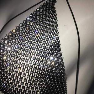 Macro shot of sparkling rhinestones on black mesh fishnet bikini top with halter straps