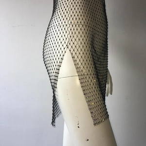 Detail of black mesh cover-up skirt with sparkling rhinestones and a high side slit design