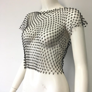 Close-up of black mesh crop top with shimmering rhinestones on a white mannequin