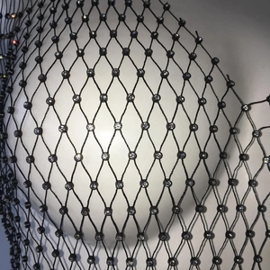 Macro view of black fishnet mesh fabric with sparkling white rhinestones on a dress