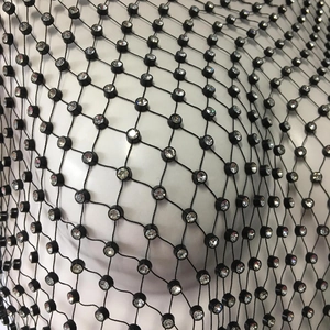 Detailed close-up of black fishnet top featuring sparkling rhinestones on mesh grid