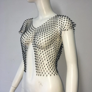 Détail du haut en résille noire orné de strass brillants sur tissu transparent