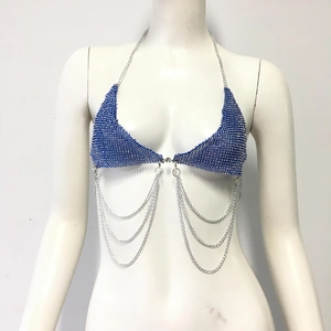 Détail du haut dos nu en strass bleus avec chaînes en métal argenté superposées