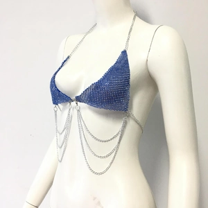 Détail d'un haut de bikini à strass bleus avec franges métalliques et fines chaînes