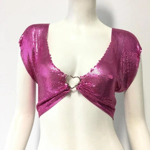 Détail d'un haut à paillettes roses avec une boucle en métal en forme de cœur argenté