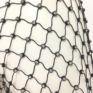 Detailed close-up of rhinestone fishnet fabric with black mesh and sparkling crystals