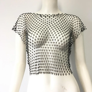 Macro shot of black mesh crop top featuring detailed rhinestone embellishments and textures