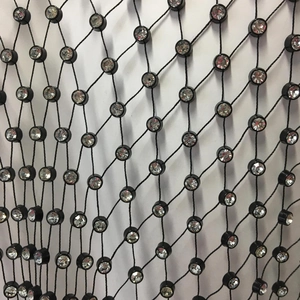 Vue macro du tissu en maille noire avec strass scintillants sur le haut en filet