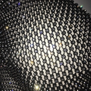 Nahaufnahme des schwarzen Netzstoffs mit funkelnden Details aus Strass und Kristallen