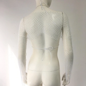 Detailed view of white rhinestone fishnet top with long sleeves and open back ties