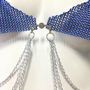 Détails de la maille en strass bleu avec de fines chaînes en métal argenté suspendues