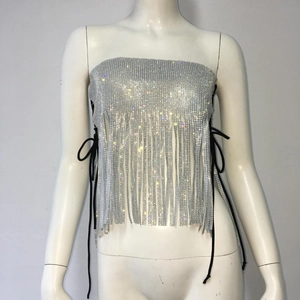 Détails des franges en strass argentés étincelants et des lacets noirs sur cette mini-jupe