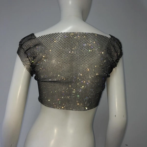 Detail eines schwarzen Strass-Netz-Oberteils mit schimmernder, halbtransparenter Textur