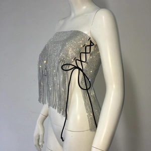 Détail d'un haut à paillettes argentées avec laçage latéral et franges scintillantes