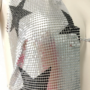 Détail de haut en maille à paillettes métalliques avec motif étoile noire et chaînettes