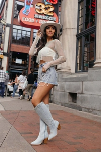 Damen Strass-Oberteil mit Netzoptik kombiniert mit Denim-Shorts und coolen Westernstiefeln