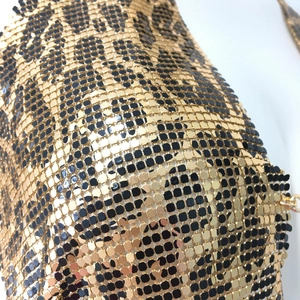 Vue macro du tissu à mailles métalliques à paillettes léopard dorées et noires