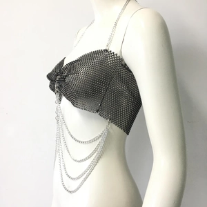 Dettaglio del crop top a rete nero con strass luminosi e spalline a catena argento