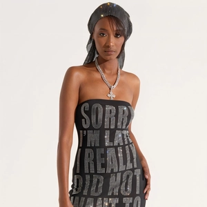 Close-up of sparkling rhinestone text on black tube dress for party and clubwear