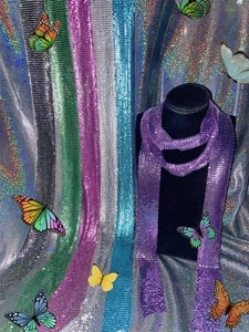 Detail of colorful metallic sequin scarf collection showing purple and silver mesh textures