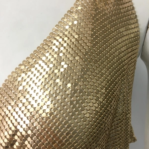 Detail of shimmering gold metal sequin mesh fabric on a sexy party dress