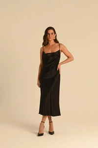 Détail d'une robe midi en satin noir avec col bénitier et bordure en dentelle