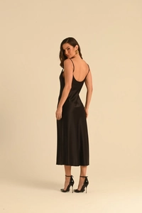 Gros plan sur la robe nuisette en satin noir montrant la texture lisse et brillante