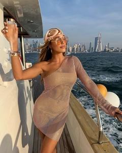 Détail d'une robe en résille marron clair avec strass étincelants et manche asymétrique