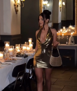 Detail of gold metallic halter mini dress with deep V neckline and draped collar design