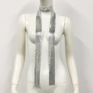 Macro detail of a silver metallic sequin skinny scarf with reflective punk style texture