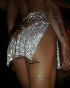 Makroaufnahme des silbernen Pailletten-Minirocks mit glitzernden Kristallen und Funkeln