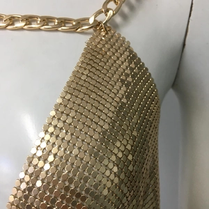 Détails macro de sequins métalliques dorés et chaîne épaisse sur la robe de soirée