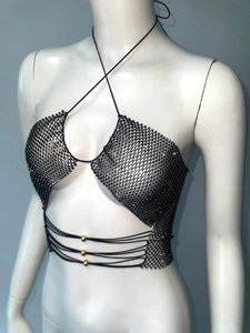 Detail eines sexy schwarzen Netztops mit glänzenden Strasssteinen und Goldperlen